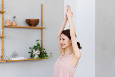 Young Asian woman practicing yoga at homeの写真素材