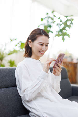 Young Asian woman using a mobile phoneの写真素材