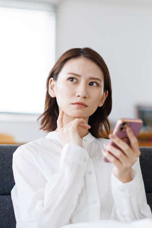 Young Asian woman using a mobile phoneの写真素材