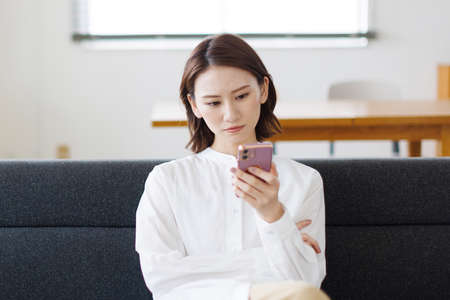 Young Asian woman using a mobile phoneの写真素材