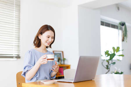 Young Asian woman having a video call on a laptopの写真素材