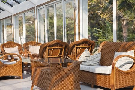old-fashioned cane chairs and table in the lounge of a glass building.の写真素材