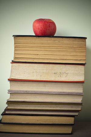 books and apple on the green wall background in home.の写真素材