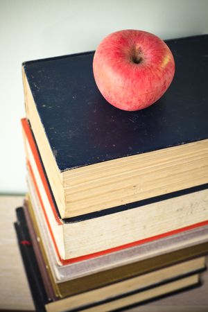 books and apple on the green wall background in home.の写真素材