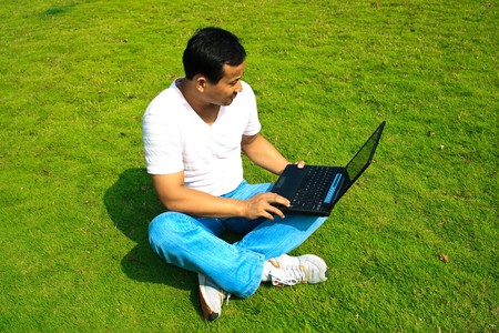 man using laptop in a garden outdoor.の写真素材