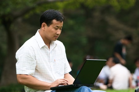 man using laptop in a garden outdoor.の写真素材