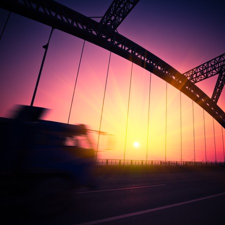 truck speeding through a bridge at sunset,motion blur.の写真素材
