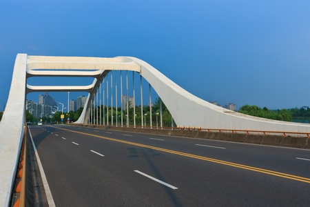 road through the bridge with blue sky background of a city.の写真素材