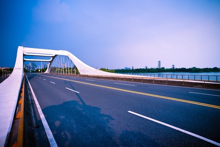 road through the bridge with blue sky background of a city.の写真素材