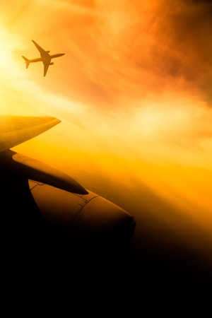 airplane fly at sunset sky background.の写真素材
