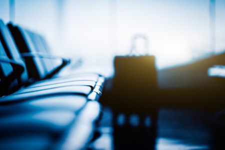 Empty seat and a luggage in airport,blue toned.の写真素材