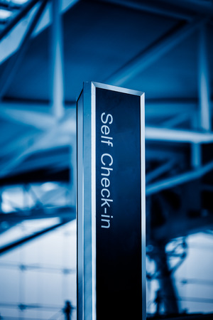 self check-in sign in airport,chongqing china,blue toned image.の写真素材