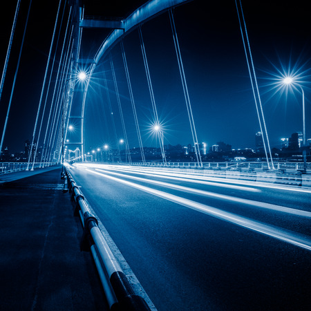 traffic trails on bridge,chongqing china,blue toned image.の写真素材