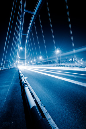traffic trails on bridge,chongqing china,blue toned image.の写真素材