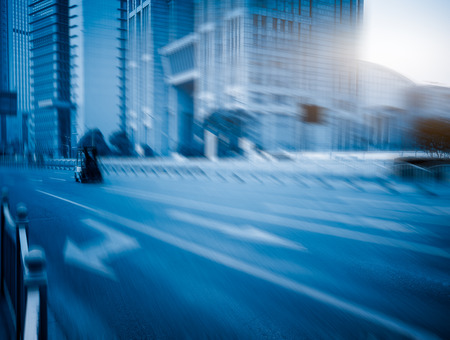 blurred city road against office buildings,blue,toned,image.の写真素材