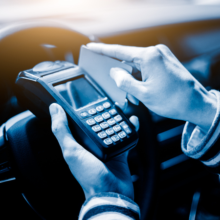 man in a car swiping credit card on wireless POS machineの写真素材