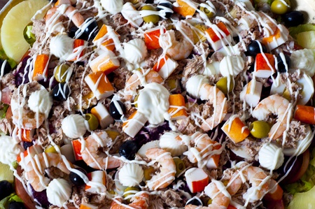 a plate of seafood salad with olives and pineappleの写真素材