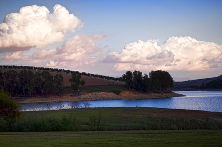 lake ,trees and hill with cloudy sky as background