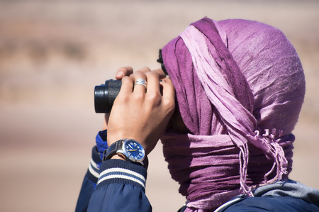 young man looking with binocularsの写真素材