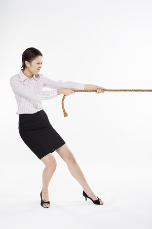 Businesswoman pulling a tightropeの写真素材