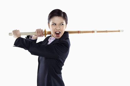 Businesswoman swinging a kendo stickの写真素材