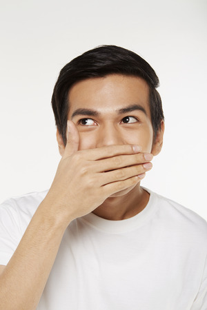 Man covering mouth with handの写真素材
