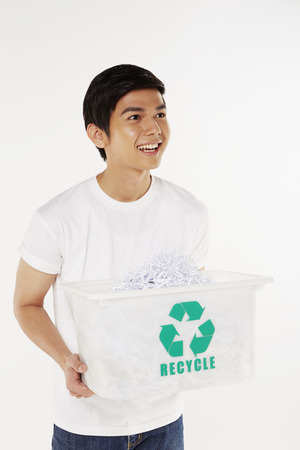 Man carrying a plastic box filled with shredded paperの写真素材