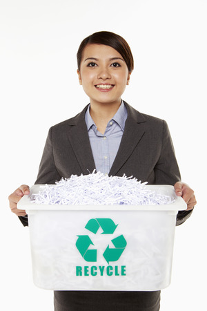 Businesswoman carrying a box filled with shredded paperの写真素材
