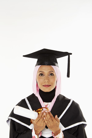 Woman in graduation robe, prayingの写真素材
