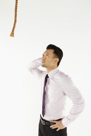 Businessman staring at a rope, contemplatingの写真素材