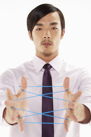 Businessman forming a cat's cradleの写真素材