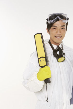 Man in protective suit holding a metal detectorの写真素材
