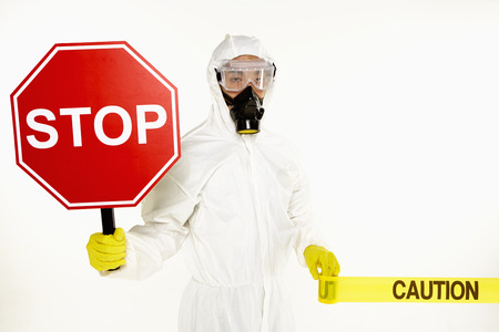 Man in protective suit holding a 'Stop' signの写真素材