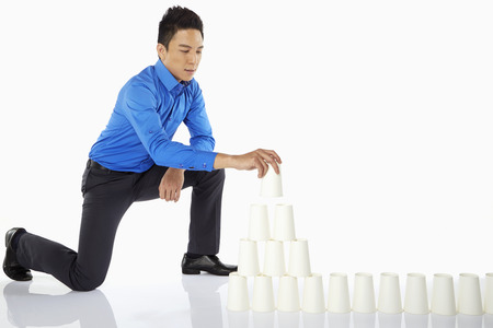 Businessman arranging disposable cupsの写真素材