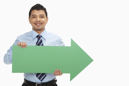 Businessman holding up an arrow, pointing to the left