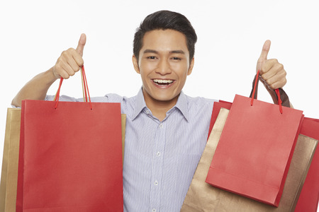 Man carrying shopping bags and showing hand gestureの写真素材