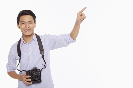 Man with digital camera pointing to the leftの写真素材