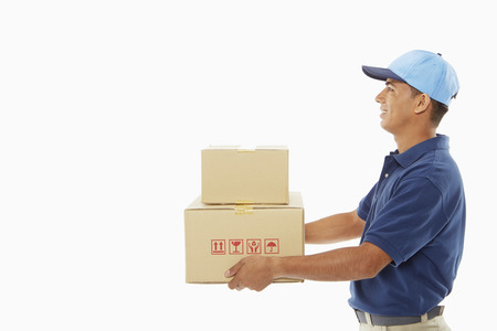Delivery person carrying cardboard boxesの写真素材