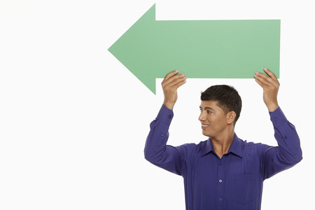 Businessman holding up a green arrow, pointing to the rightの写真素材