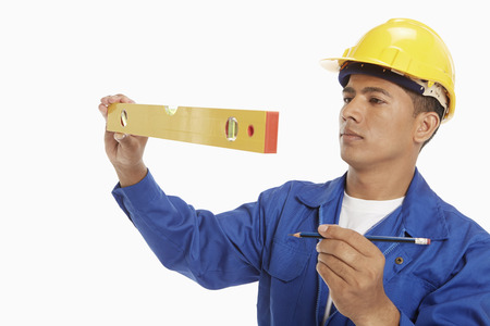 Construction worker measuring with a spirit levelの写真素材