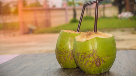 soft focus of coconut juice and brown tube on wooden tableの写真素材