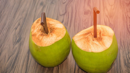 soft focus of coconut juice and brown tube on wooden tableの写真素材