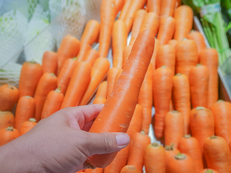 on selective focus of Customers are selecting carrots from the trayの写真素材