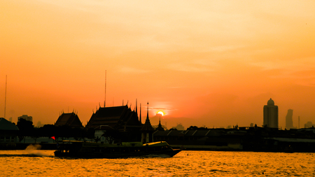 soft focus of The silhouette of the temple and the boat in the river. In the light of the morning sun.の写真素材
