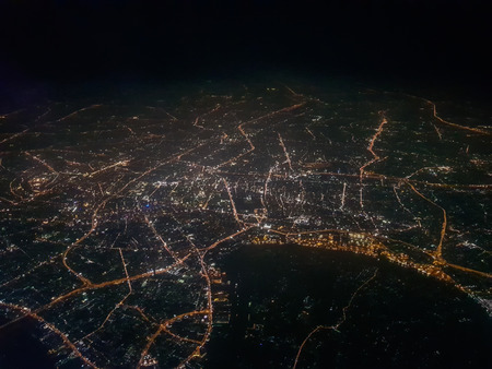 The picture is dark and blur of lights in the city view from the airplane.の写真素材