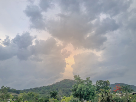 Overcast skies and clouds shaped like a face. Floating above the mountains.の写真素材