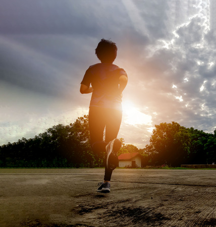 Silhouette of woman who goes jogging in the morning at the Park.の写真素材