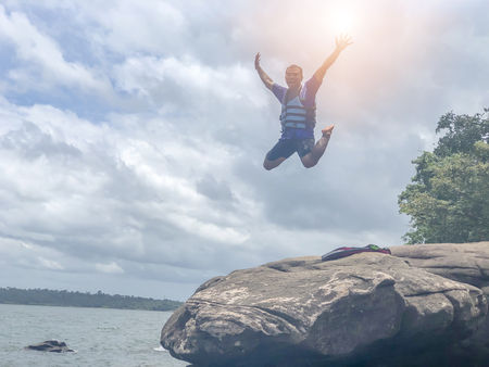 Ubon Ratchathani, THAILAND- AUG 30 2018:Male tourists are water jump from the rocks at the river lumdomenoi.のeditorial素材