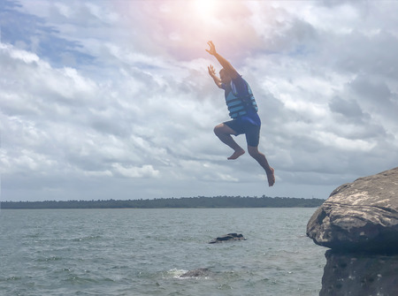 Ubon Ratchathani, THAILAND- AUG 30 2018:Male tourists are water jump from the rocks at the river lumdomenoi.のeditorial素材