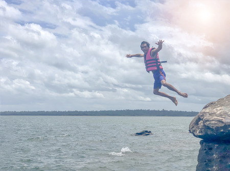 Ubon Ratchathani, THAILAND- AUG 30 2018:Male tourists are water jump from the rocks at the river lumdomenoi.のeditorial素材